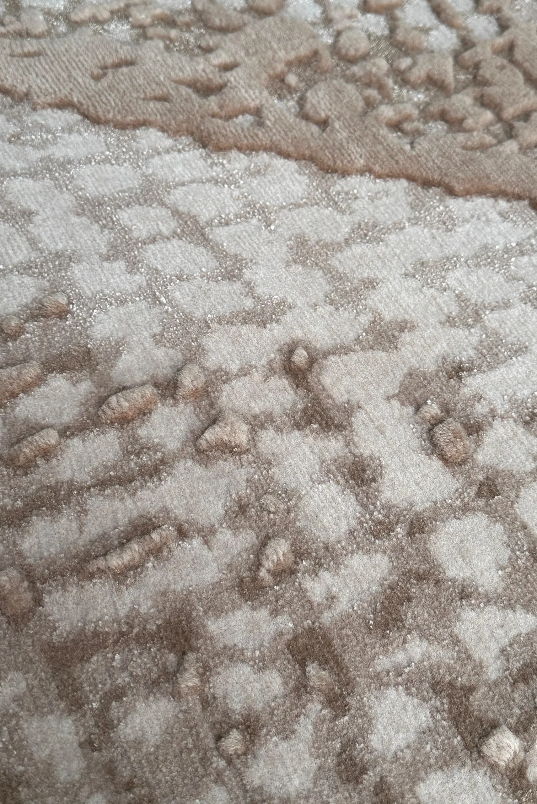 Close-up of hand-knotted details of zephyr rug showing tonal sand textures with varying pile heights, highlighting the interplay of wool and silk and the depth of Northwest 35 craftsmanship.​