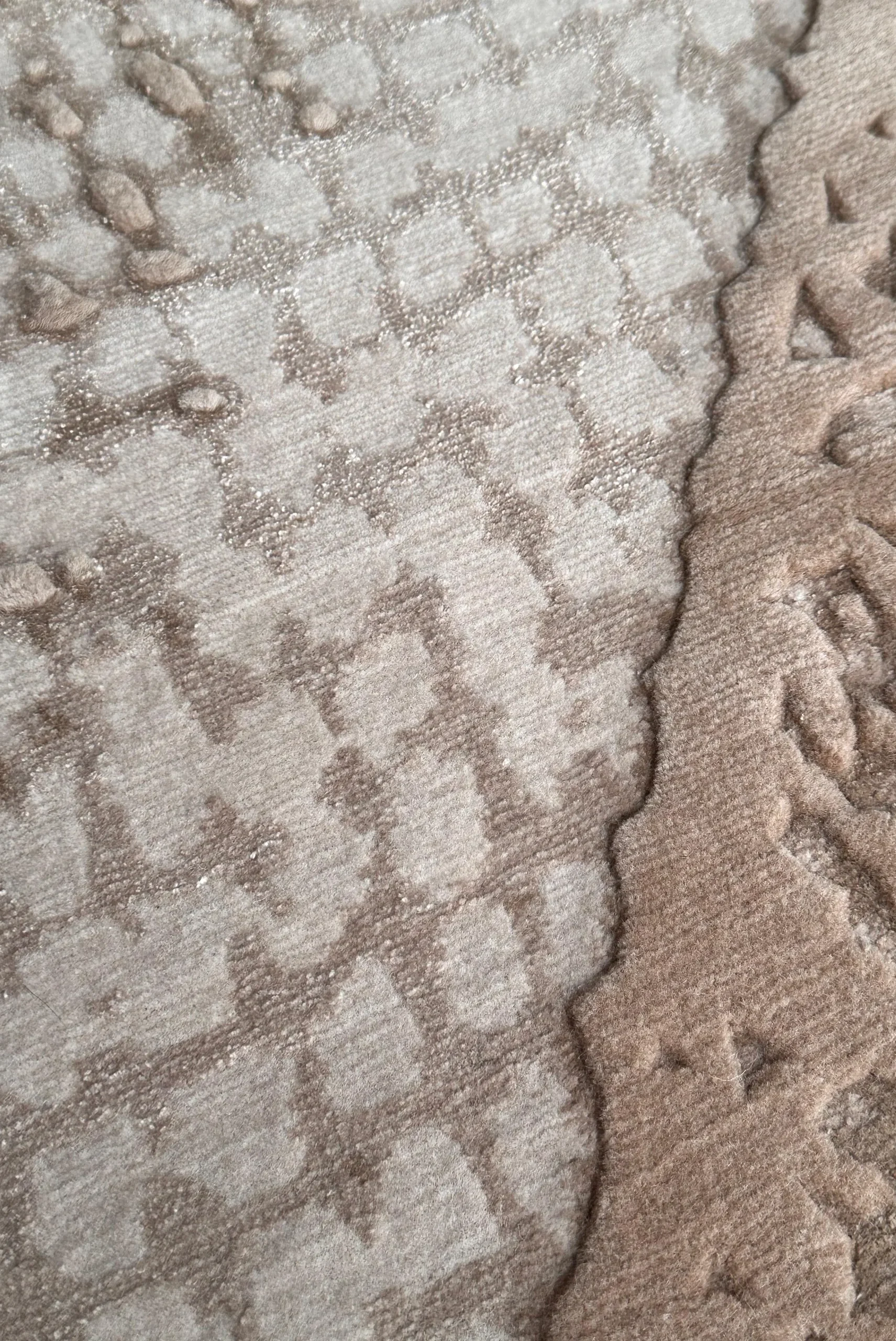 Close-up of hand-knotted details of zephyr rug showing tonal sand textures with varying pile heights, highlighting the interplay of wool and silk and the depth of Northwest 35 craftsmanship.​