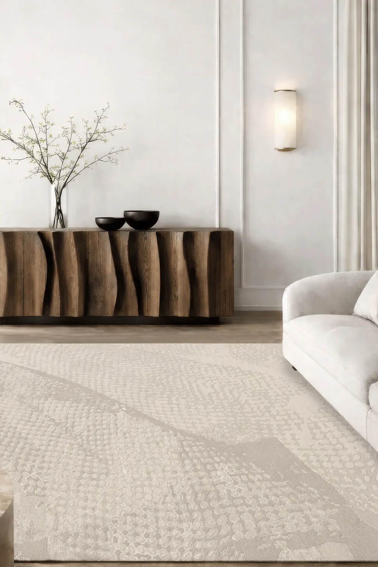 Luxury hand-knotted rug in soft sand tones with subtle abstract textured pattern inspired by light and shadow, styled in a contemporary interior with sculptural wooden sideboard and neutral sofas, showcasing Northwest 35 craftsmanship.​